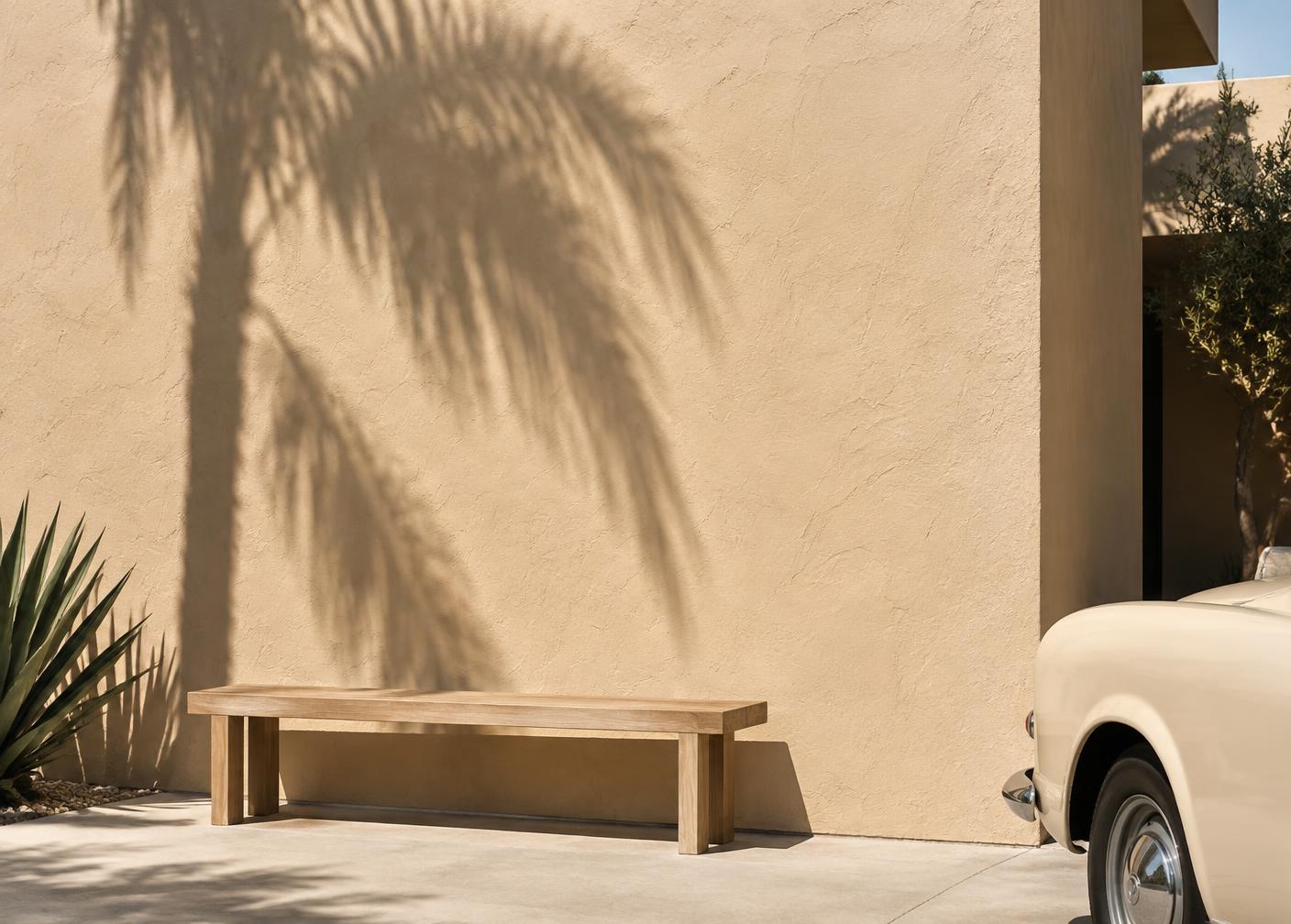 Warm stucco wall and oak bench outside the Nexa Motors showroom